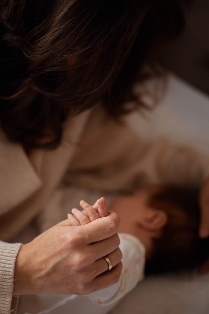 Mãe segurando a mão do filho na hora de dormir