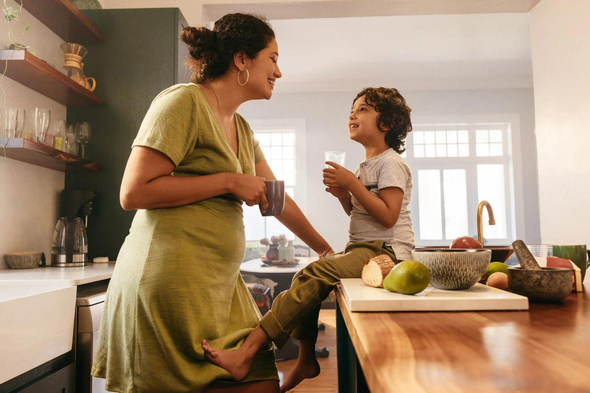 Mãe e filho conversando na cozinha durante a rotina do dia